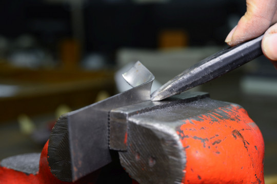 Správný úhel naklopení sekáče – špička míří přesně do koutu a dotýká se čelisti svěráku